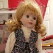 Identifying a Porcelain Doll - doll wearing a floral print skirt and vest