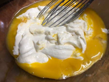 adding cream cheese mixture to egg yolks