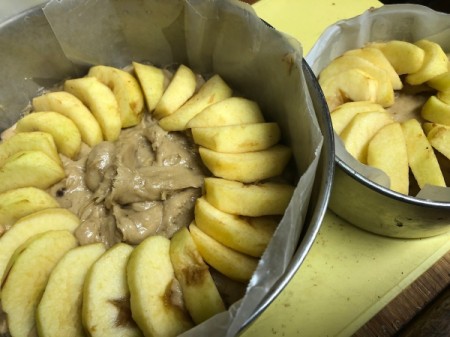 lining top of cake with apple slices on Cake