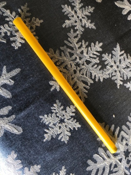 A large straw used for watering a floral arrangement.