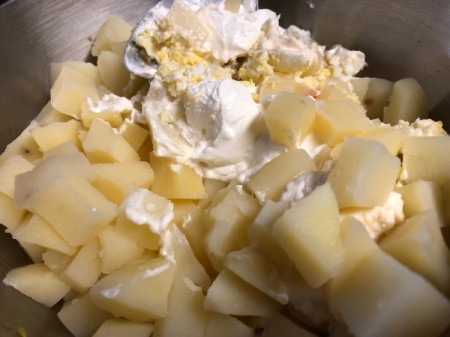 adding seasoning, sour cream and mayonnaise to salad