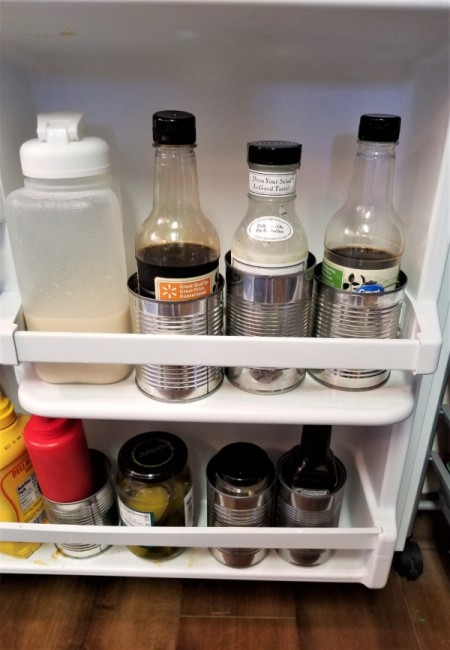 Cans in the refrigerator to stabilize and contain condiments.