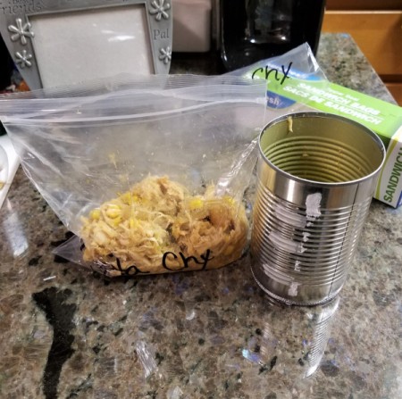 A filled ziptop bag next to the can used to fill it.