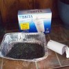 Repurpose Spent Water Filter Cartridges - charcoal from a water filter in an aluminum baking pan