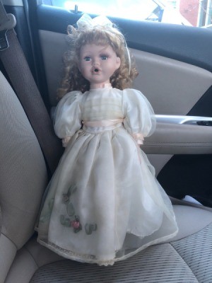 Identifying a Porcelain Doll - doll wearing a long white dress with a pink ribbon sash