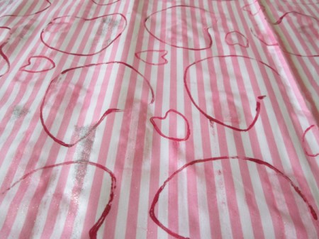 Recycled Paper Rolls as Heart Stamps - red hearts stamped on pink and white striped fabric