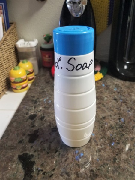 A Soda Stream container repurposed into a container for laundry soap.