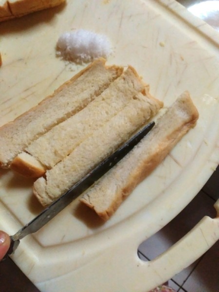 cutting buttered bread slice