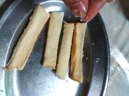 sprinkling Garlic Breadsticks with salt