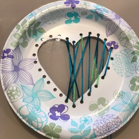 Heart Paper Plate Sewing Craft - beginning to thread yarn through the holes