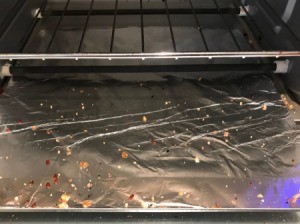 A toaster oven's crumb tray, covered in aluminum foil.