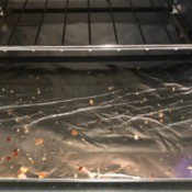 A toaster oven's crumb tray, covered in aluminum foil.