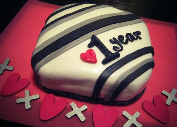 A decorated cake celebrating a 1 year anniversary.