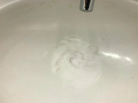 A pile of salt and baking soda piled in a sink drain.