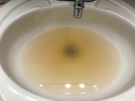 Adding boiling water to help clear blocked drain.