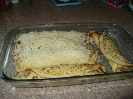 cheese covered crepes in baking dish