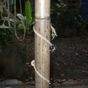 Making a Bamboo Rain Stick - braid some string and decorate the instrument. Be sure to glue the string in place.