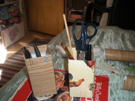 Recycled Butter Boxes Used as Pencil Holders - boxes with pens, pencils, scissors, and more inside