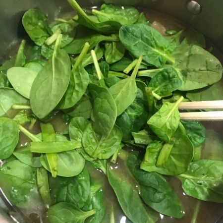 adding spinach to broth