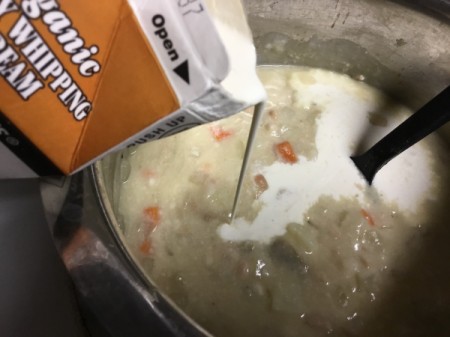 adding whipping cream to chowder