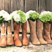 A row of boots with flowers for a country themed wedding.
