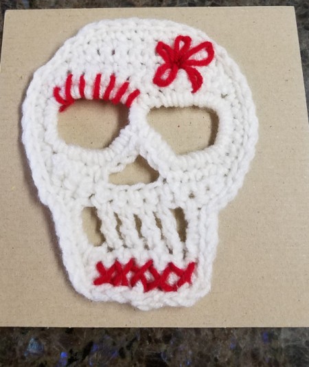 Crocheted Sugar Skull - add red yarn flower and details