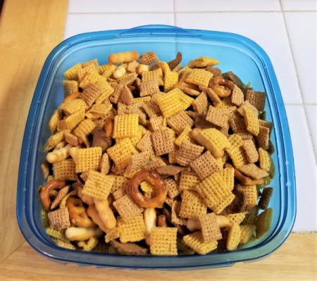 Party mix stored in a plastic container.