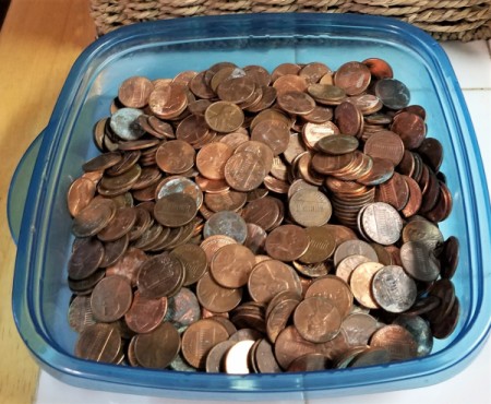 A collection of change in a plastic container.