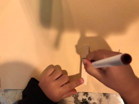 Imaginary Clothespin Flying Butterfly - child using a marker to decorate the clothespin