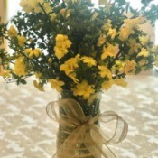 Yellow flowers in a vase decorated with ribbon.