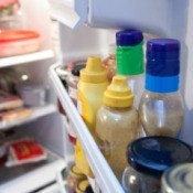 A row of condiments in the refrigerator.