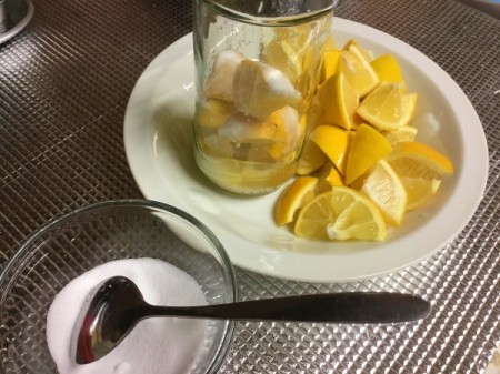 Lemon pieces, jar and salt