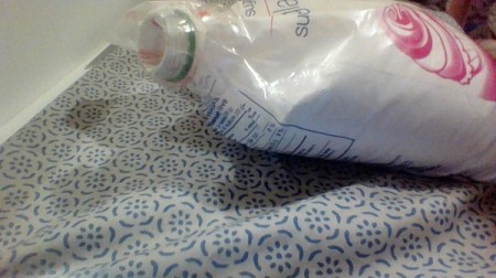 Using a recycled bottle and cap to seal powdered sugar.