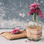 Small glass vase wrapped in burlap, lace and twine.