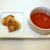 Grilled cheese hearts next to a bowl of tomato soup.