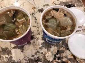 Two recycled food containers with leftover soup stored inside.
