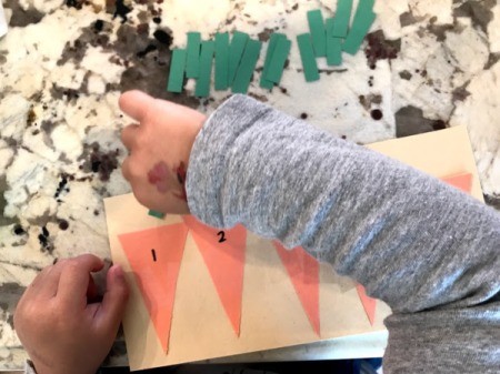 Carrot Counting Activity for Toddlers - child adding a leaf