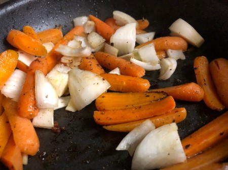 adding carrots and onions to pan