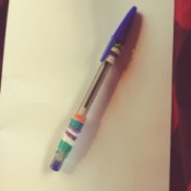 A pen with colorful rubber bands wrapped around it.