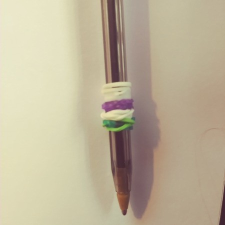 A pen with colorful rubber bands wrapped around it.
