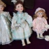 Value of Leonardo Collection Porcelain Dolls - three dolls on a black background