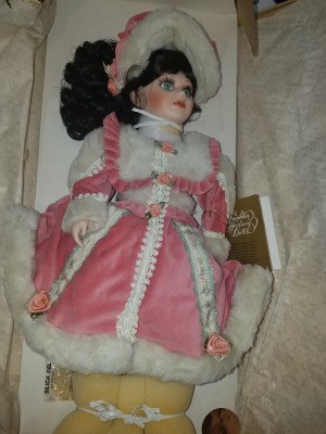 Value of a Franklin Heirloom Doll - doll wearing a bright pink outfit with white fur trim and matching hat