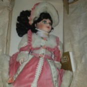 Value of a Franklin Heirloom Doll - doll wearing a bright pink outfit with white fur trim and matching hat
