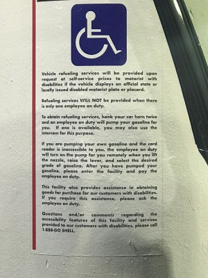 A gas station sign with information for handicapped customers.