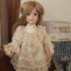 Identifying a Porcelain Doll - doll wearing a lace trimmed off-white dress