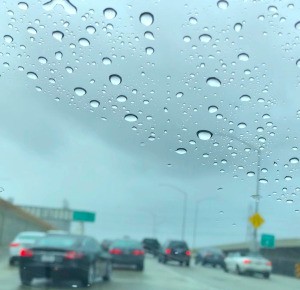 A windshield that is clear at the bottom and with water spots at the top.