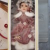 Value of a Seymour Mann Porcelain Doll - doll in box wearing a dusty rose outfit with white fur trim