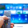 A television remote pointed at a smart TV with lots of apps.