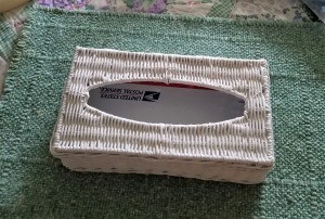 A wicker tissue box with a hole in the top.