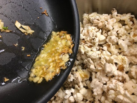 pouring garlic oil on Popcorn